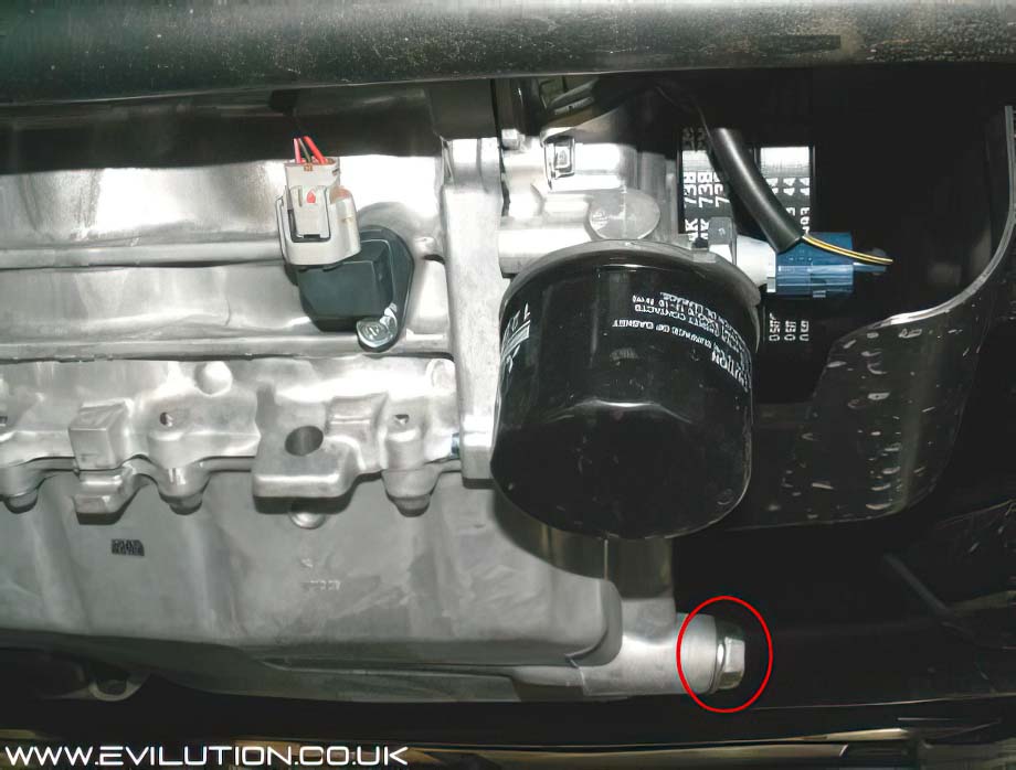 Where is the engine oil drain plug located on a car?